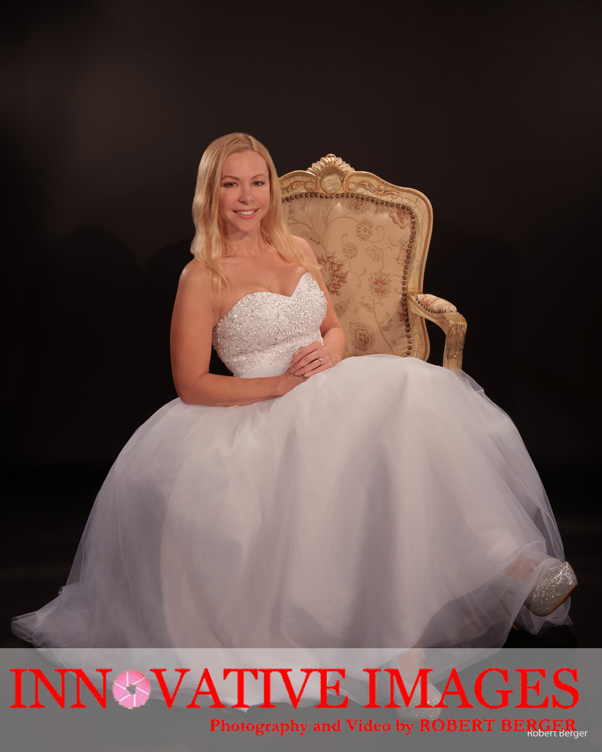 Bride in wedding dress photographed in photography studio sitting down in a casual pose. professional studio portrait using hollywood glamour lighting by Innovative Images Photography by Robert Berger in Houston Texas